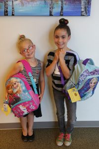 Children receiving backpacks