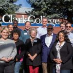 Members of the Presidential Selection Committee smiling in front of the Clark College sign