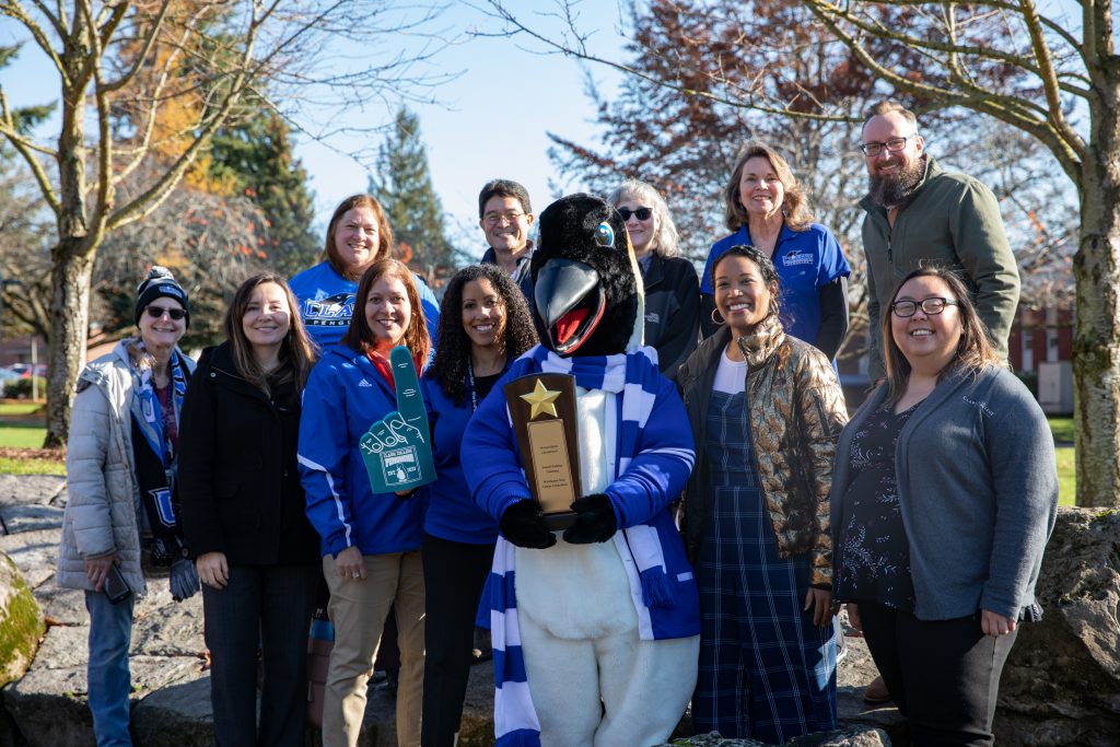Oswald holding Walktober trophy with smiling Clark employees in Japanese Garden