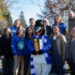 Oswald holding Walktober trophy with smiling Clark employees in Japanese Garden
