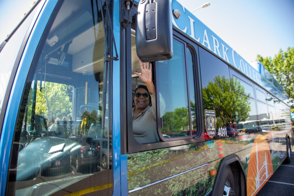 Dr. Edwards in the driver's seat of C-TRAN's new bus featuring Clark College's image.