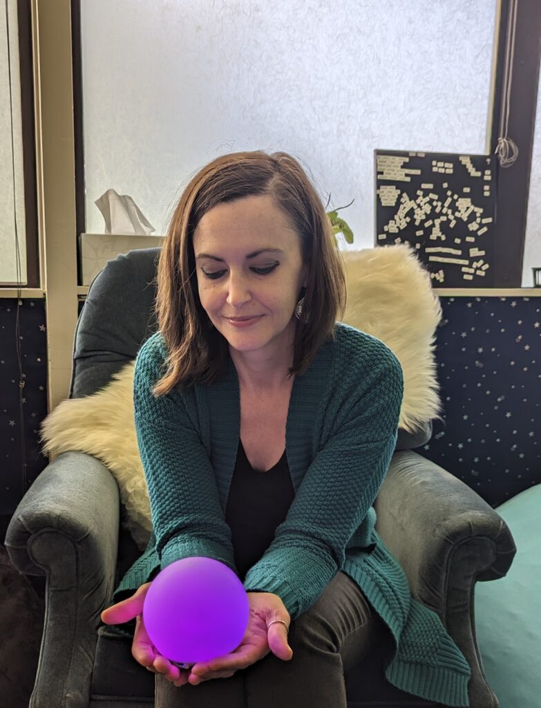 Counselor Shayna Collins holds a sensory light and watches it change color.