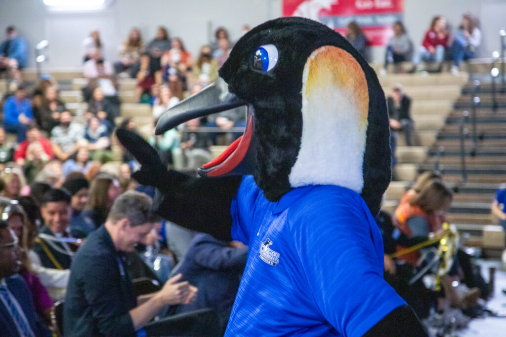 Oswald, the penguin mascot, waves to the crowd.