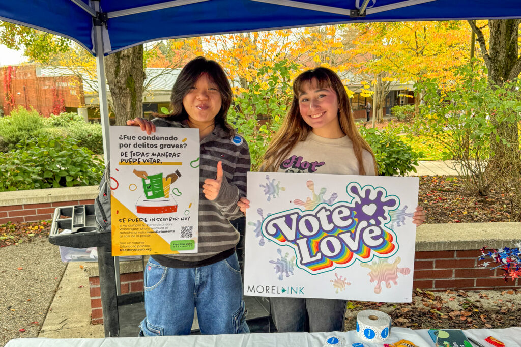 two people holding voting signs