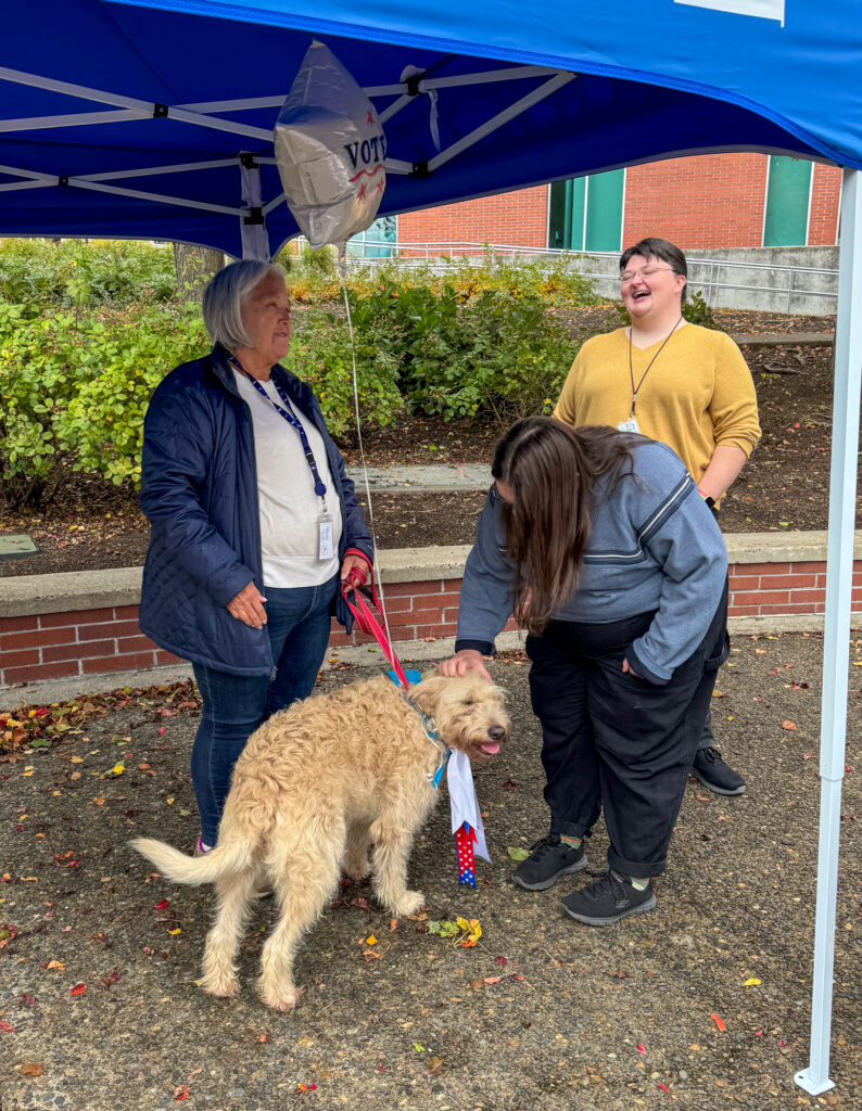 three people with dog