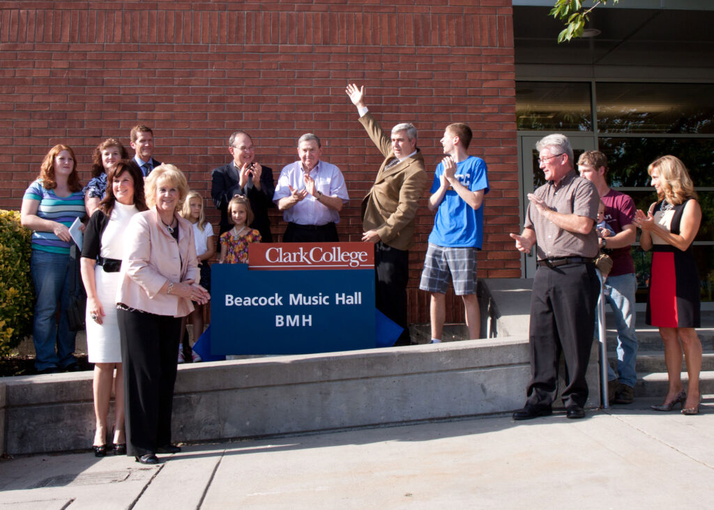 A group of people standing in front of a sign.