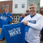 Former Clark College's President holding up a shirt that reads "Best of the West".