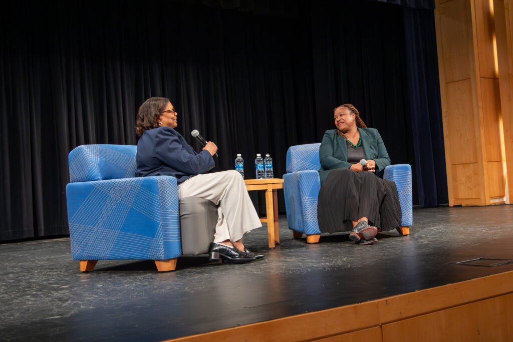 two people seated on stage
