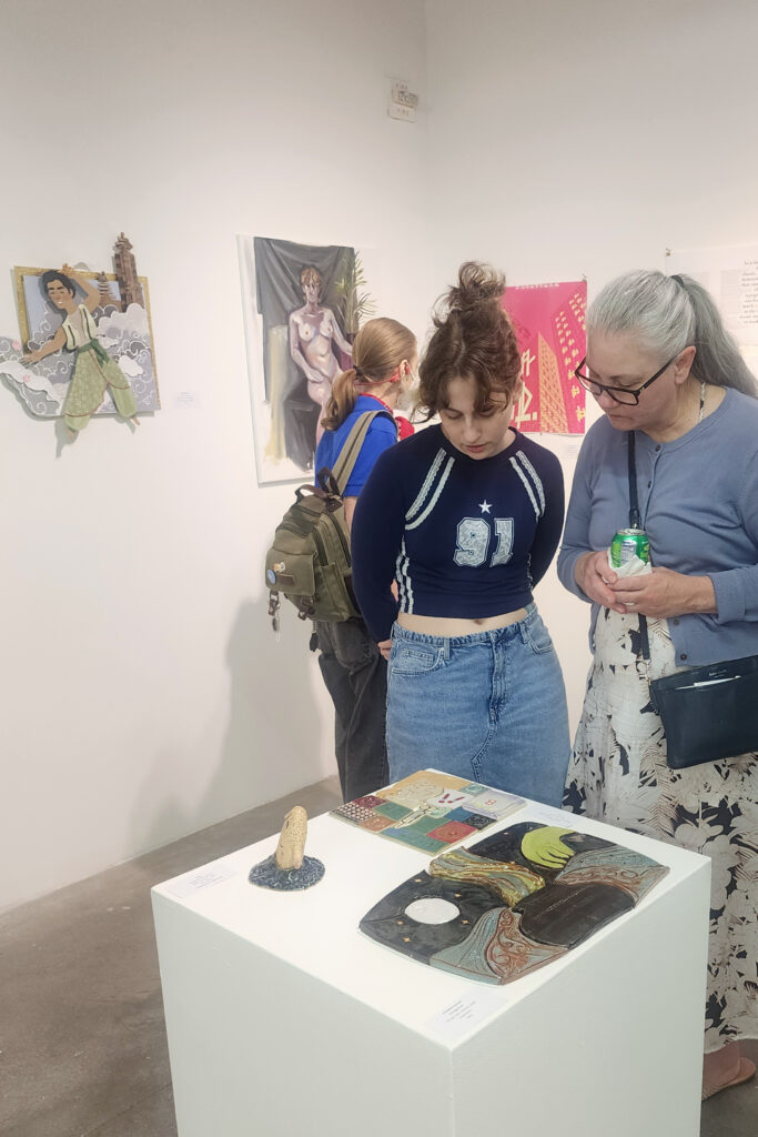 two people look at art