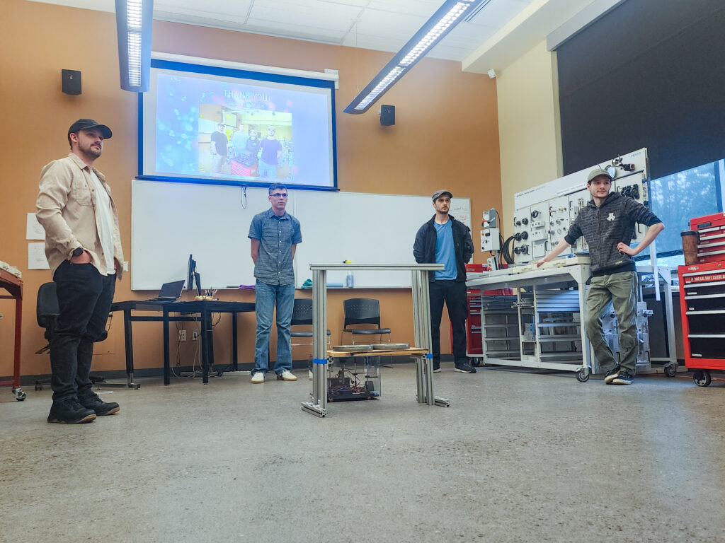 four people stand in a mechatronics lab