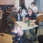 people seated at tables looking at books