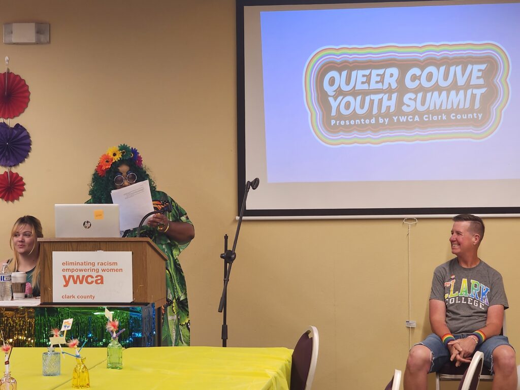 person at podium, and person seated watching them