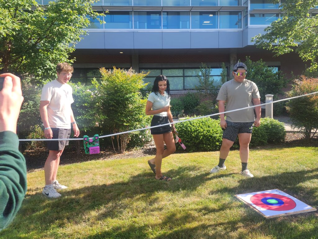 three people watch an object move across a string