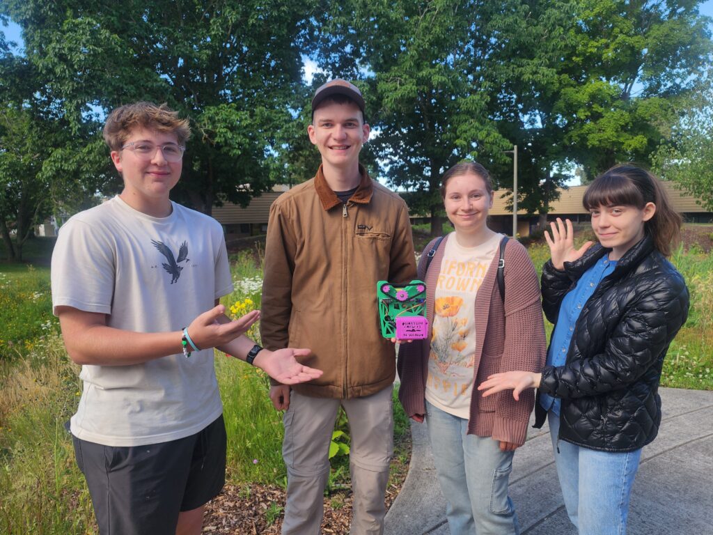 four people pose with their device