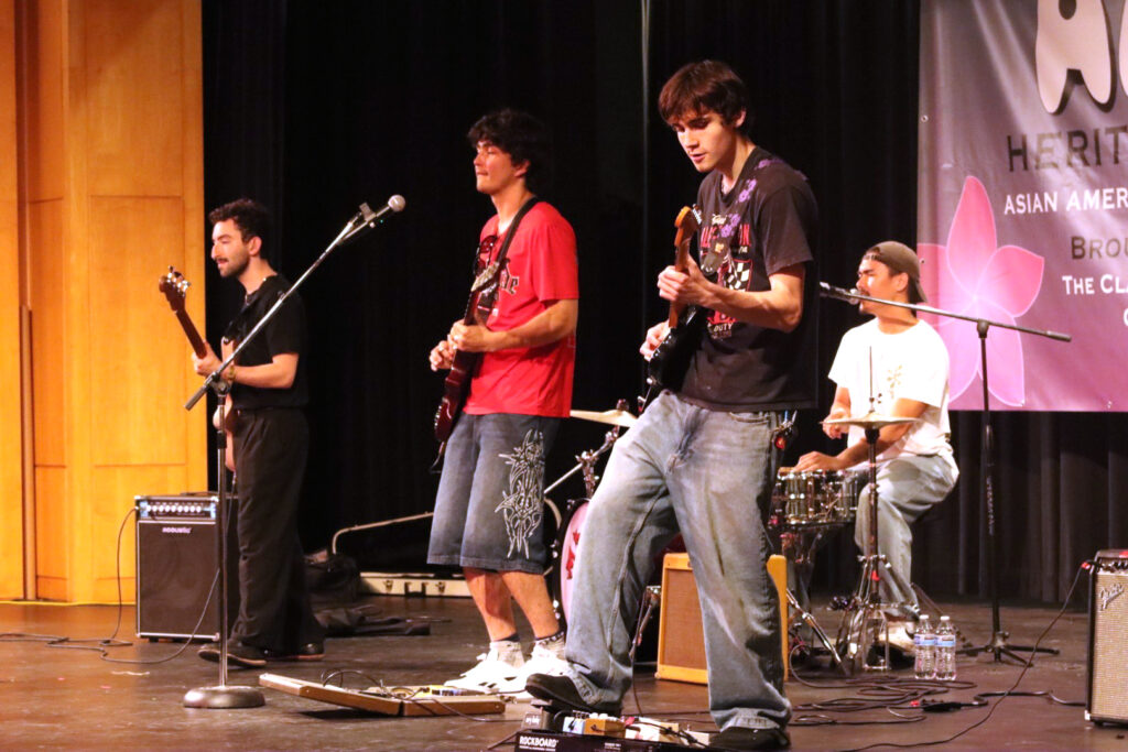 4 people on stage playing instruments