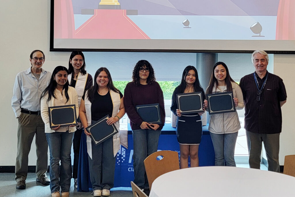 Line of people facing camera holding certificates