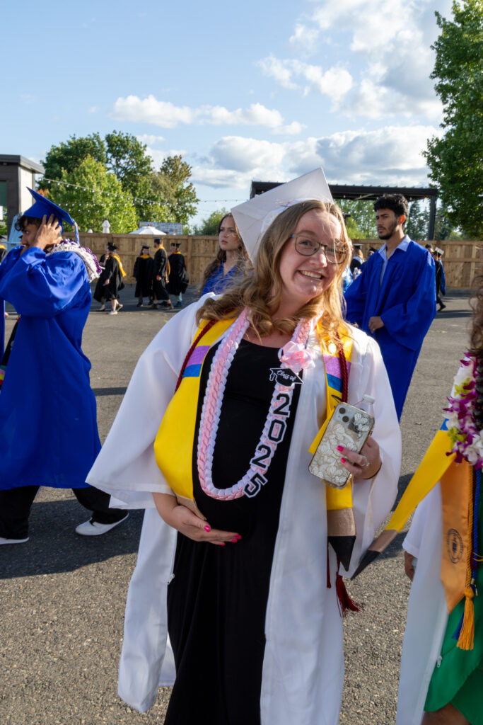 person holding stomach in cap and gown