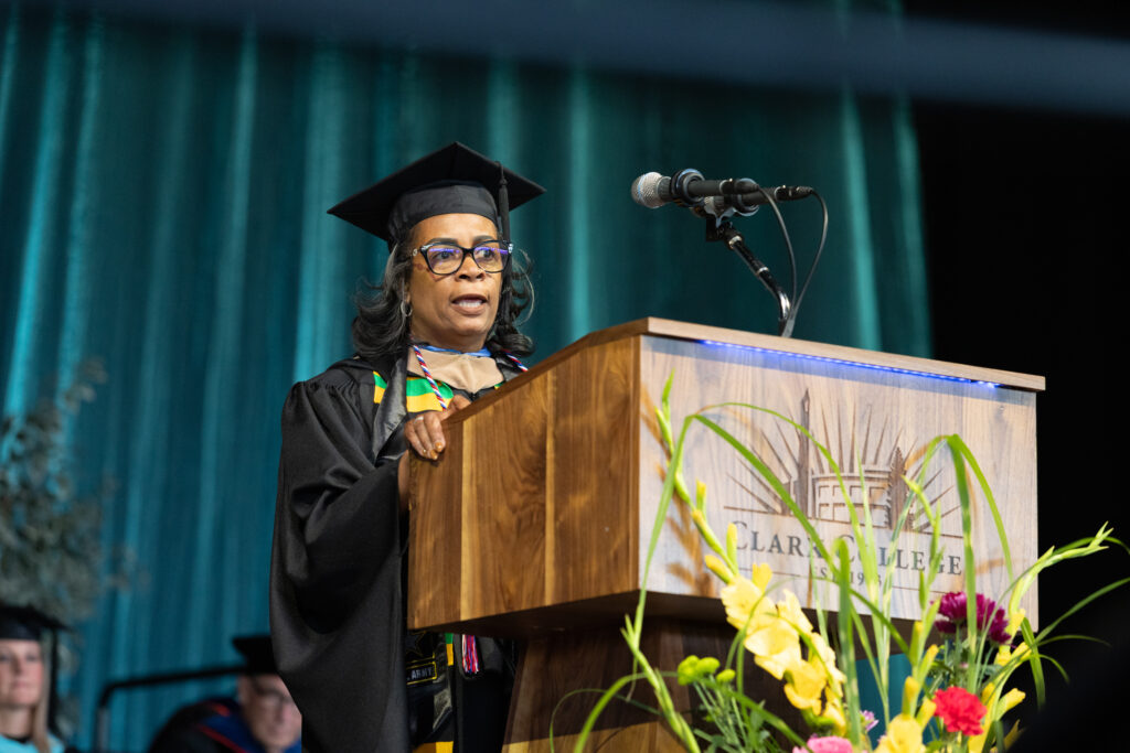 person at podium in cap and gown