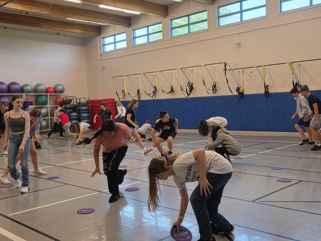 A group of young students playing together in a gym.