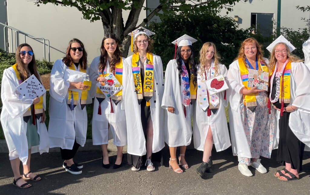 group of students in caps and gowns decorated stoles and caps.